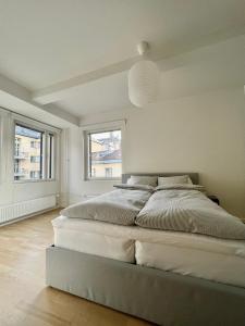 biała sypialnia z dużym łóżkiem i oknami w obiekcie modern apartment with private terrace w Helsinkach