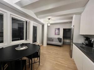 cocina y comedor con mesa negra en una habitación en modern apartment with private terrace, en Helsinki