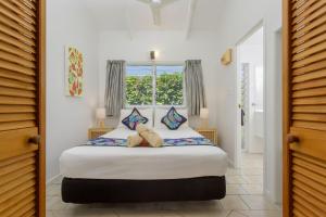 Schlafzimmer mit einem großen Bett und einem Fenster in der Unterkunft Rarotonga Daydreamer Escape in Rarotonga