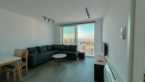 - un salon avec un canapé et une grande fenêtre dans l'établissement Urban Serenity Skyline View Apartment 2, à Tirana