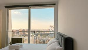 a room with a bed and a large window at Urban Serenity Skyline View Apartment 2 in Tirana