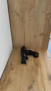 a black controller sitting on top of a wooden floor at Urban Serenity Skyline View Apartment 2 in Tirana