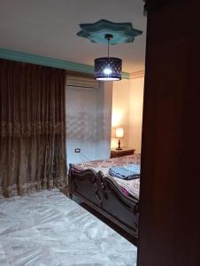 a bedroom with a bed and a chandelier at شقة مفروشة مكيفة للايجار بجبل طارق 