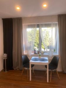 uma mesa e duas cadeiras em frente a uma janela em Apartmán 2+kk, 50 m2 v klidné lokalitě. 10 min od centra Prahy. em Praga