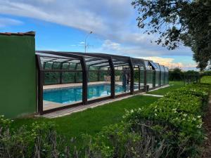 una casa de cristal con un patio con piscina en Finca Llamazares, en La Bañeza