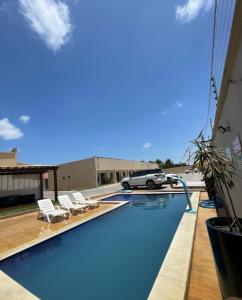 uma piscina com um carro estacionado ao lado de um edifício em DUNAS RESIDENCE CASA 02 em Santo Amaro