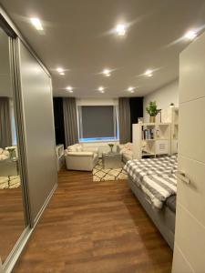 um quarto com uma cama e uma sala de estar em Apartmán 2+kk, 50 m2 v klidné lokalitě. 10 min od centra Prahy. em Praga