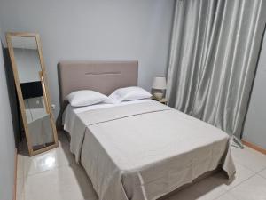1 dormitorio con 1 cama grande y espejo en Aconchegante Refúgio Beira-Mar en Praia