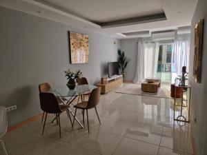 a living room with a glass table and chairs at Aconchegante Refúgio Beira-Mar in Praia