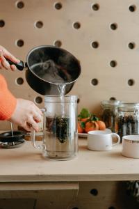 a person is stirring food in a pot on a counter at KeepCalm Treehouse far from the civilization 