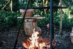 a fire pit with food cooking in it at KeepCalm Treehouse far from the civilization in Smidary