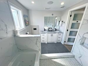Baño blanco con lavabo y espejo en Limeridge Mall - Open Concept en Hamilton