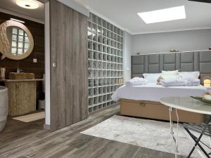 een slaapkamer met een groot bed en een tafel bij Fonte Retreat Premium Suite in Sandim