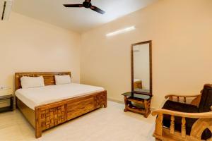 um quarto com uma cama, uma ventoinha de tecto e uma cadeira em OYO Hotel Umrao em Patna