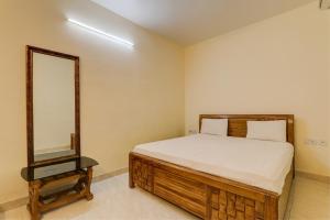 OYO Hotel Umrao في باتنا: غرفة نوم بسرير ومرآة