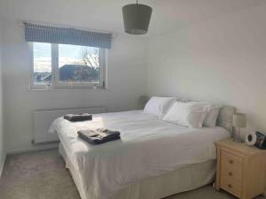 a bedroom with a large white bed with a window at Cosy flat in the Heart of Wandsworth in London