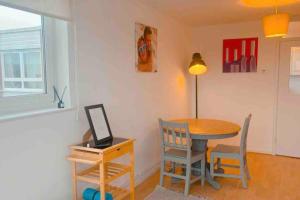a dining room with a table and chairs and a lamp at Cosy flat in the Heart of Wandsworth in London