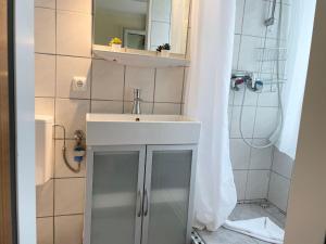 y baño con lavabo blanco y ducha. en Frauenpreiss-Whg-47, en Cuxhaven