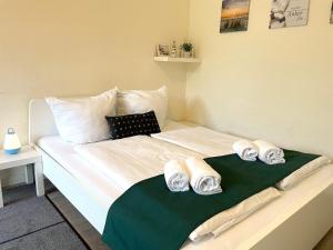 1 dormitorio con 1 cama con 2 toallas en Frauenpreiss-Whg-47, en Cuxhaven