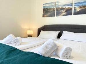 Duas camas com lençóis brancos e almofadas num quarto em Strandhochhaus-Whg-J12 em Cuxhaven