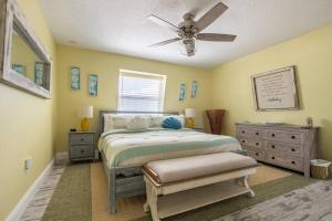 een slaapkamer met een bed en een plafondventilator bij Summer Rayne in Cocoa Beach