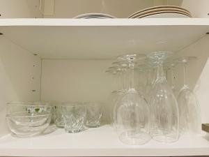 a bunch of glass vases and bowls on a shelf at Etzel Ferienwohnung (Einzimmerwohnung) in Würzburg