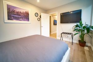 a bedroom with a bed and a flat screen tv at Hamilton Mountain Plaza - King Bed - Main Floor in Hamilton