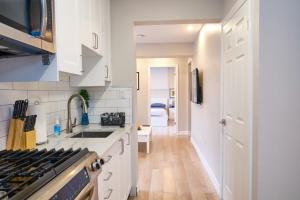 a kitchen with white cabinets and a stove at Hamilton Mountain Plaza - King Bed - Main Floor in Hamilton