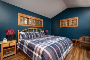 1 dormitorio con paredes azules, 1 cama y 1 silla en Boyne Mountain Disciples Village Unit 660, en Boyne Falls