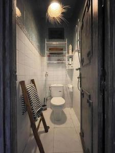 Elle comprend une petite salle de bains pourvue de toilettes et d'une chaise. dans l'établissement cristal appart, à Essaouira
