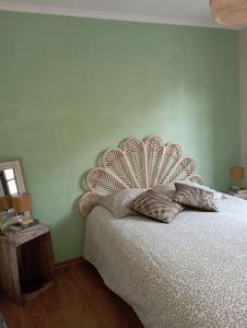 a bedroom with a bed with a fancy headboard at Le logis de Thaïs in Henrichemont