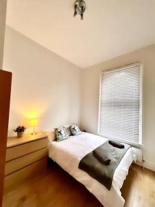 een slaapkamer met een groot bed en een raam bij Maida Vale Serenity: 2-Bedroom in Londen