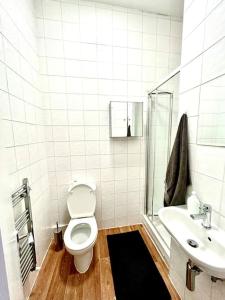 een witte badkamer met een toilet en een wastafel bij Maida Vale Serenity: 2-Bedroom in Londen