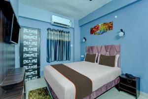 a bedroom with a bed and blue walls at Collection O Hotel Dream Villa in Patna