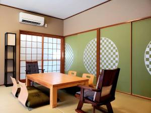 comedor con mesa de madera y sillas en 竹の宿, 
