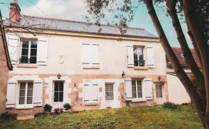 ein altes Haus mit weißen Türen und Fenstern in der Unterkunft Les Belles Pierres - HyperCentre in Amboise