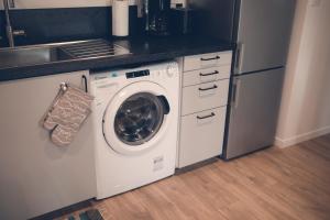 eine Küche mit Waschmaschine und Spüle in der Unterkunft Les Belles Pierres - HyperCentre in Amboise
