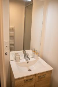 y baño con lavabo y espejo. en Les Belles Pierres - HyperCentre, en Amboise