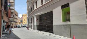 a building with black garage doors on the side of a street at Apartamento Plaza del Teatro Parking free in Málaga