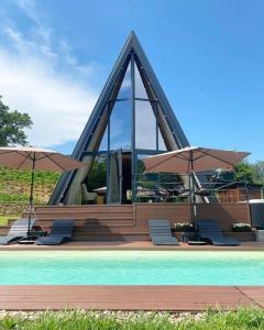 a pool with chairs and umbrellas next to a building at Forrest Relax & Spa in Rakovac