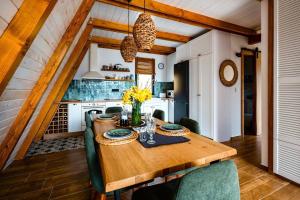 uma cozinha com uma mesa de madeira e cadeiras verdes em Forrest Relax & Spa em Rakovac
