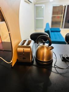 a tea kettle and a toaster on a table at Apartment on Liddiard in East London