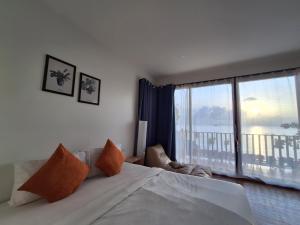 1 dormitorio con cama grande y ventana grande en Lipe Sunrise Beach House, en Ko Lipe