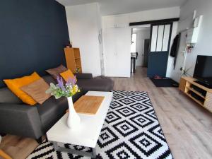 a living room with a couch and a table at Origami • Hippod. Enghien • 30 mn Paris in Eaubonne