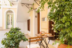 a table and chairs in a courtyard with plants at Kantirimi House - A1 in Symi
