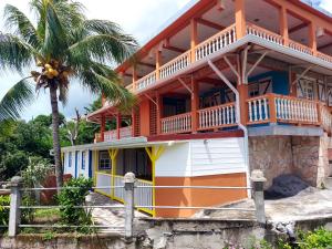 una casa en la playa con una palmera en Maison d'une chambre avec vue sur la mer jardin clos et wifi a Le Diamant a 1 km de la plage, en Le Diamant