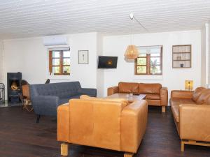 a living room with leather furniture and a fireplace at 7 person holiday home in Grenaa in Grenå