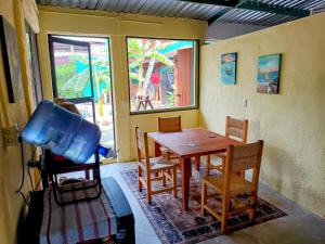 Habitación con mesa, sillas y ventana en ORidleys Hostel16, en Barra de Potosí