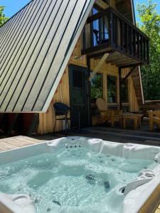 a hot tub in front of a log cabin at Mount Snow A Frame with Jacuzzi in Dover