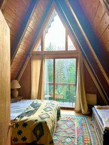 a bedroom with a bed and a large window at Mount Snow A Frame with Jacuzzi in Dover